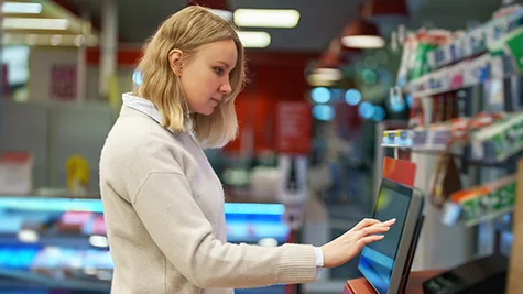 customer at self checkout operating the digital screen